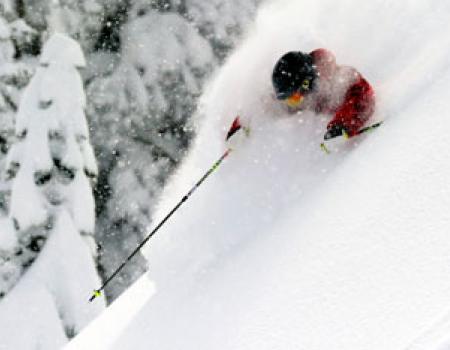 man skiing through fresh powder