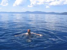 man swimming in blue waters of lake tahoe